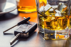 Car Keys And Glass Of Alcohol On Table